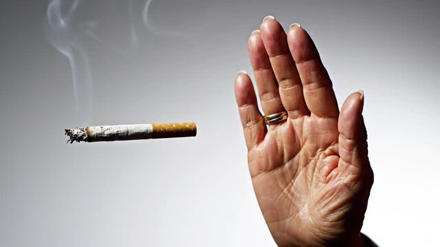 Smoking cigarette floating in air with wisps of smoke, isolated on gray background
