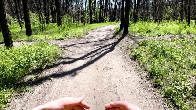 POV video of a man choosing between two paths in a sunny spring forest and deciding to turn left. Concept of choice, decision making, and adventure