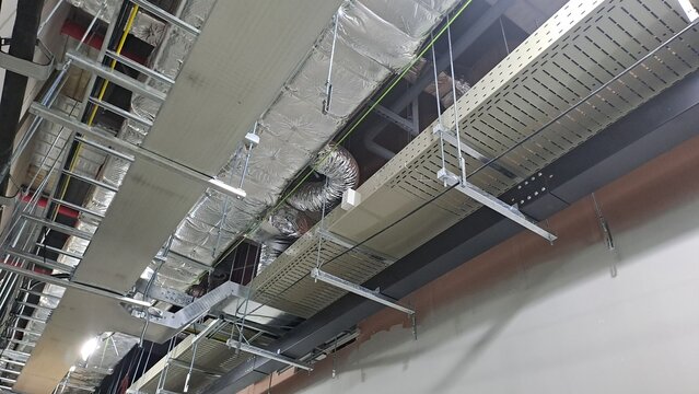 industrial hvac ducts and metal cable trays on the ceiling of a data center under construction