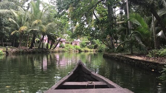 POV View from a Wooden Boat Rowing through a Quiet Village Canal in India