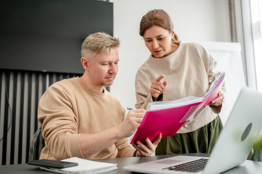 Man Working With Assistant In Office With Documents