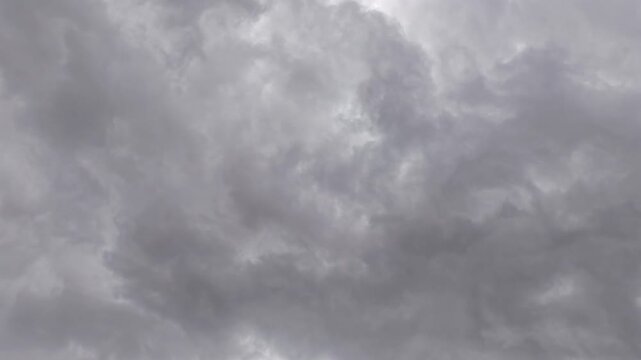 A dramatic drone timelapse captures swirling storm clouds rolling like a giant ocean wave. The intense atmospheric motion creates a powerful, cinematic weather transition.