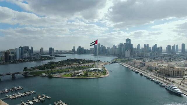 A giant UAE flag waves over the city of Sharjah, United Arab Emirates.