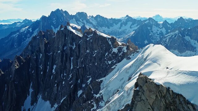 Cinematic aerial footage of snowy alpine peaks and glacier ridges in Chamonix, France, with a natural parallax effect, ideal for travel, adventure, nature, and epic landscape projects