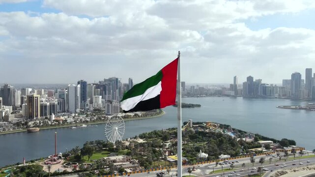 The UAE flag is seen waving above the urban landscape of Sharjah.