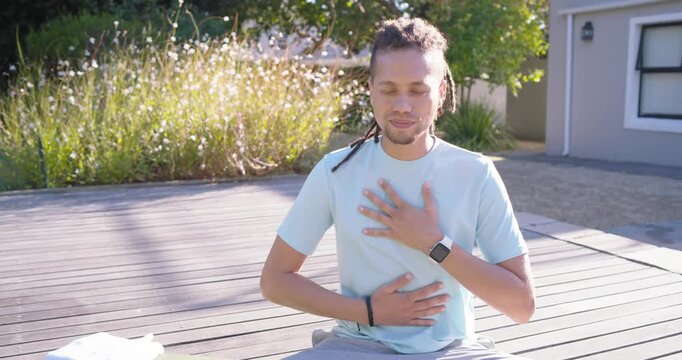 Guided breath guiding African American man sitting on mat breathing then standing smiling for calm