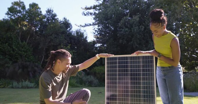 African American couple positioning and inspecting solar panel, checking lower corner alignment