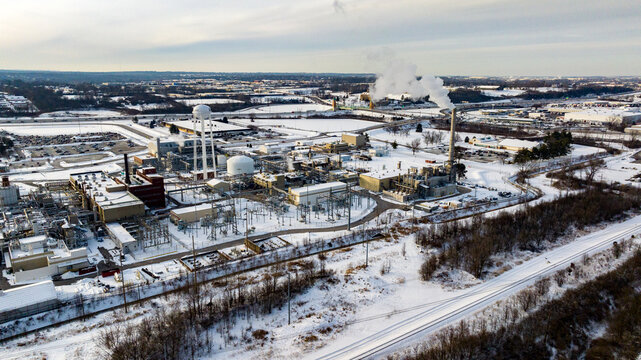 Aerial view of an industrial facility with smoking chimneys and snow-covered grounds under an overcast winter sky Reading, Ohio, United States.