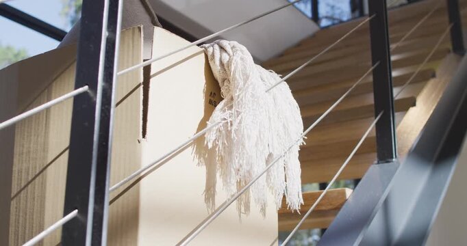 Camera is shifting, nudging white fringed throw on rails at stairwell to reveal texture and treads