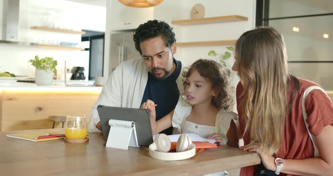Diverse family at kitchen table responding to tablet, using red stylus and notebook for homework