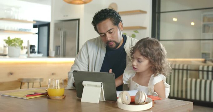 African American dad and child following tablet, dad guiding orange stylus, teaching at home