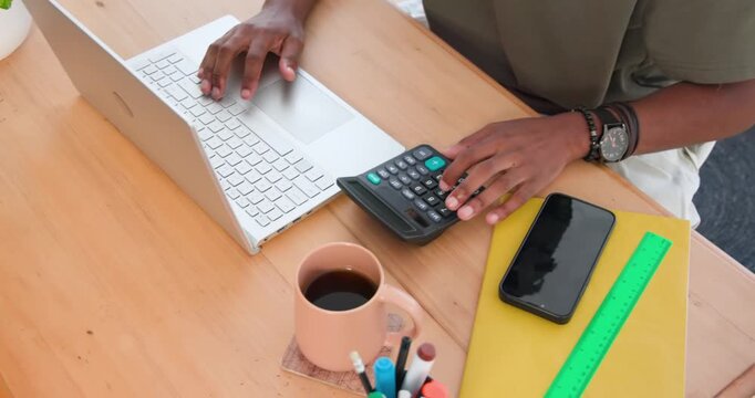 Male student typing on white laptop, shifting right hand to black calculator, verifying numbers