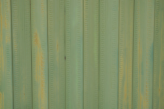 Green corrugated metal wall texture with vertical fluted pattern, perfect for backgrounds and graphic design