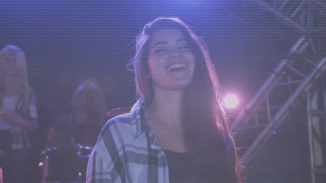 Drummer starting beat, female music singer tilting head and opening mouth to sing, lens flare