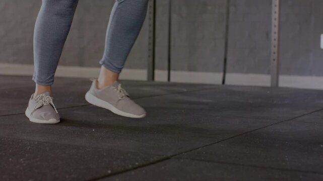 Woman starting from forward lunge on rubber floor, pushing right heel and stepping for fitness