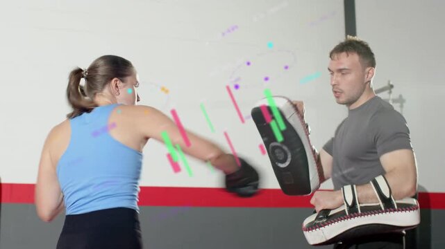 With boxing coach holding mitts, trainee training combos, pads moving, graphics highlighting hits