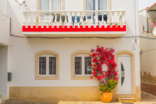 White house facade with balcony and blooming flowers