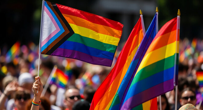 Close-up of rainbow and pride flags waving in a crowd, symbolizing LGBTQ+ pride, diversity, and celebration, perfect for social justice or event concepts