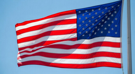 Fototapeta premium American flag waving against a clear blue sky