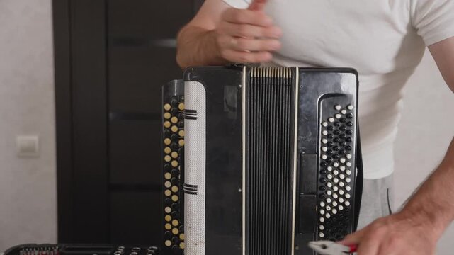 Technician repairing old accordion with screwdriver