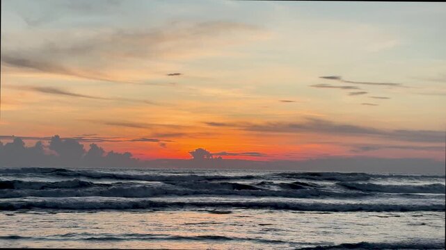 Summer sunset over the sea with golden light with waves