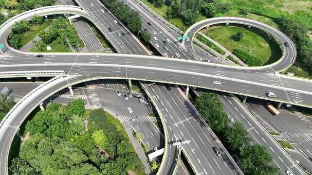 Busy Urban Cloverleaf Highway Interchange with Traffic and Green Parks