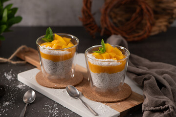 Two Glass Cups of Chia Seed Pudding Layered with Mango Purée and Fresh Mint © homydesign