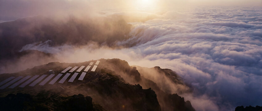 Mountain Solar Panels Above Clouds at Sunrise