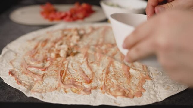Chef adding pineapple to chicken shawarma wrap with sauce