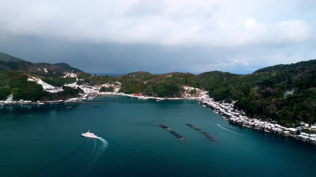 雪景色の伊根の舟屋 4Kドローン空撮 伝統的建造物群保存地区と伊根湾 冬の絶景