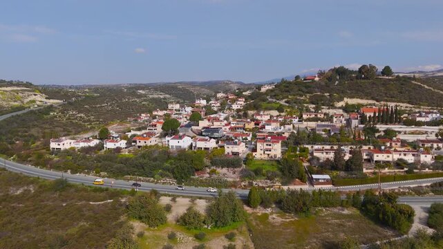 Aerial Drone Descent Over Alassa Village and Busy Main Road Traffic in Cyprus