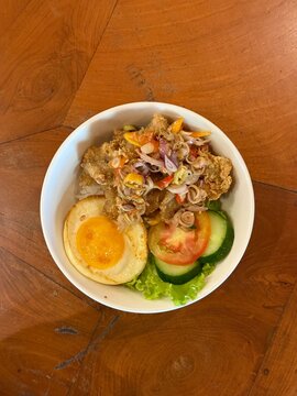 Rice bowl on the table. Crispy Dory Fish with Balinese Sambal Matah on Rice Bowl, Indonesian food. Nasi dori sambal matah