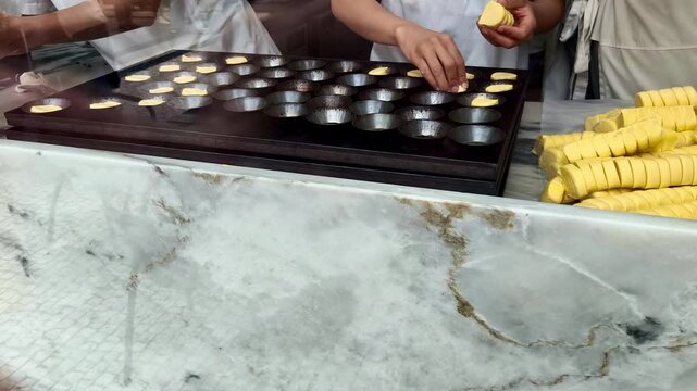 Pastel de nata Portugu&eacute;s, pastelero poni&eacute;ndo hojaldre en bandeja para horno