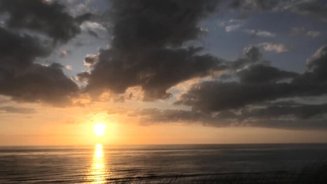 Ziehende Wolken bei Sonnenuntergang am Meer, Nordsee, Zeitraffer, Niederlande