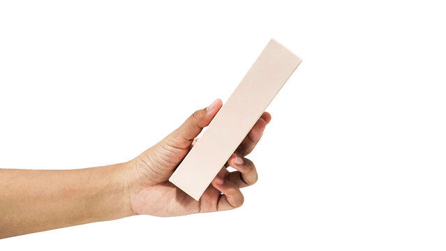 Close-up of a hand holding a blank cream-colored rectangular box, isolated on a white background. Concept of product packaging, unboxing, and mock-up delivery.