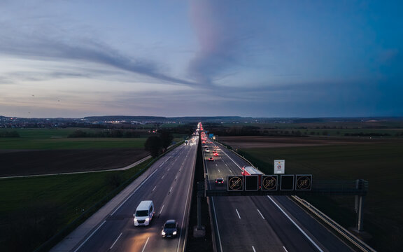 Aerial view of highway traffic at dusk with the digital speed limit signs in the countryside