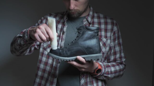 Shoe care in action as cream is applied to a black leather boot. The scene highlights cleaning, conditioning and restoring footwear quality.
