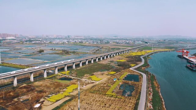 Elevated railway bridge over wetlands and river near city