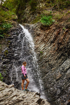 Zhenetskyi Huk Waterfall. Hiking near a waterfall with rocky cliffs and flowing water. Summer Hiking in Carpathian Mountains. Ukraine