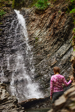 Zhenetskyi Huk Waterfall. Hiking near a waterfall with rocky cliffs and flowing water. Summer Hiking in Carpathian Mountains. Ukraine