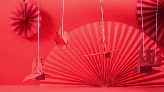 Red Origami Cranes Hanging Over Paper Fan Decorations