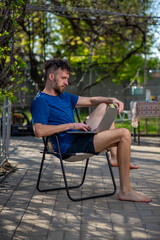 Fototapeta premium Man Working on Laptop in Backyard Patio