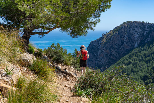 Alcudia, Mallorca, Spanien: Wanderung zum Gipfel Talaia d'Alc&uacute;dia im Norden der Insel - Ausblick aufs Meer und die traumhafte K&uuml;ste, Frau beim Wandern mit Rucksack