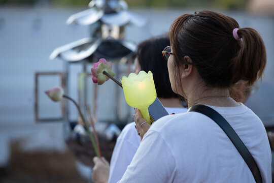 Thai candlelight procession around Buddha statue on Makha Bucha Day at Phutthamonthon, rear view.