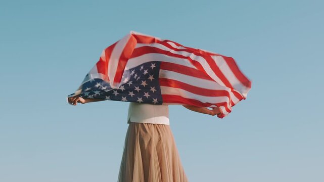 Female Waving Flag. Woman Twirling With American Banner. Lady Rotating American Flag Beneath Open Sky