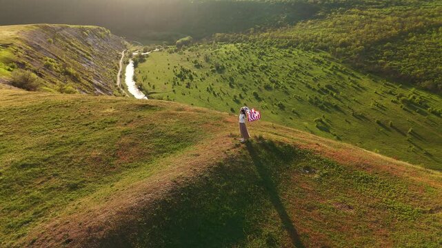 Cliffside View White Woman Carrying Flag Across Ridge Above River, Explorer Walking Toward Summit In Golden