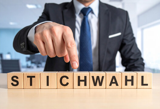 Stichwahl - Geschäftsmann zeigt auf den Text "Stichwahl"
