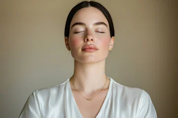 A  woman in a white silk blouse and gold jewelry © EwaStudio