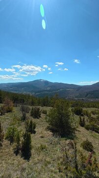 Blue sky with sun flares and scattered clouds. Ljukten peak, (Balkans, Serbia) Vertical