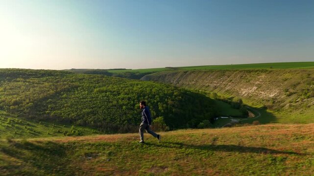 Person Running Along Canyon Rim With River, Brisk Pace, Athletic Stride, Sunlit Grassland, Expansive Horizon,